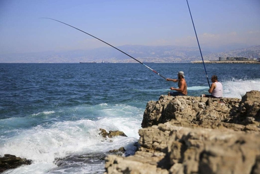 Lebanese men fish from a rocky coastal area along the Mediterranean Sea. (AP Photo/Bilal Hussein)