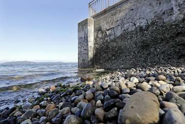 A concrete seawall along the Puget Sound juts out in the water. (AP Photo/Elaine Thompson)