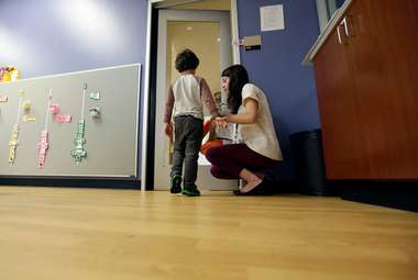The stress of caring for an autisic child is one of the many factors to contributing to higher rates of abuse among autustic children. Here, an autistic boy is helped by a preschool teacher. (AP Photo/LM Otero)