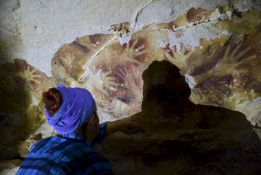 Study lead Dr. Huntley examines art-panel exfoliation. (Linda Siagian)